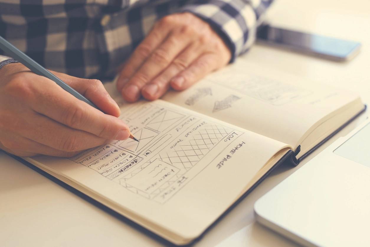 Man sketching graphic sketch in office, close up. Toned